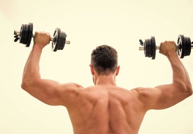 Eylemler koçlardan daha yüksek sesle konuşur. Sırtı ve kolları güçlü bir sporcu. Spor malzemeleri. Vücut geliştirme sporu. Spor yaşam tarzı. Aptal egzersiz salonu. Dambıl gibi arkadan bakan kaslı bir adam.