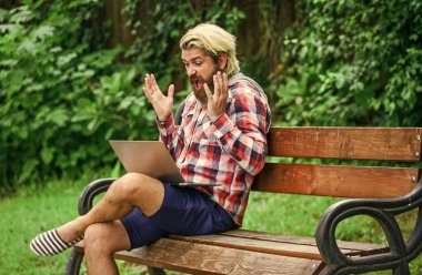Bilgisayarda çalışan olgun bir öğrenci. Pazartesi günü siber alışverişe git. Adam dizüstü bilgisayarla bankta oturuyor. Online uzak eğitim. Hipster parkta çalışmak için ilham aldı. Çevik iş. Çalışmaya odaklan.