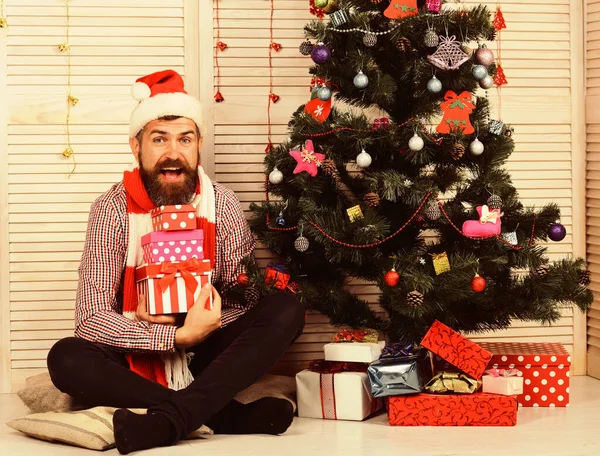 Facet z brodą trzyma prezenty. Święty Mikołaj z podekscytowaną twarzą — Zdjęcie stockowe