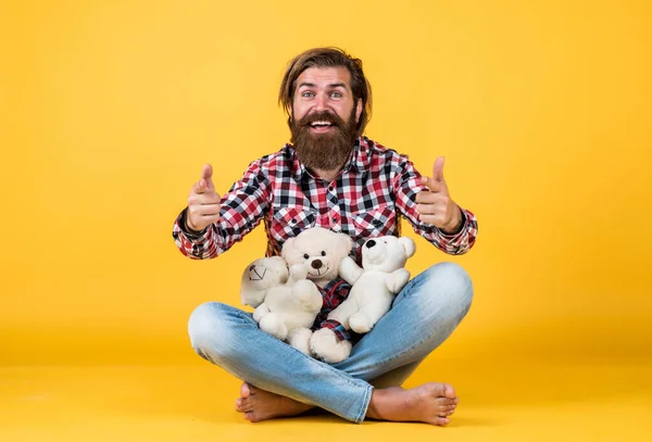 Счастливый красивый бородатый парень с небритым лицом и стильная прическа носить повседневную одежду рекомендую медвежьи игрушки, парикмахер — стоковое фото