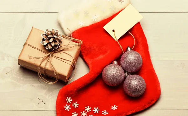 Kerst decoratieve sok licht achtergrond bovenaanzicht. Kerstsok in de vorm van een zak vullen met cadeautjes. Attributen van Kerstmis. Kerstsok met kerstcadeau doos. Gezinstradities behouden — Stockfoto