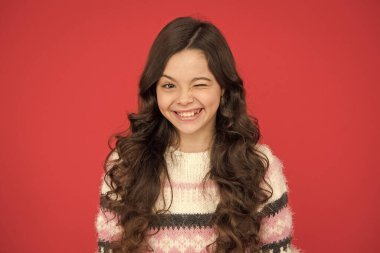 Göz kırpan surat. Doğal bukleler. Çocuk şirin, sevimli, kıvırcık saçlı. Uzun saçlı, kendine güvenen bir çocuk. Kıvırcık saçlı kız kendine güveniyor. Çocuk psikolojisi ve gelişimi. Kendinden emin duruş