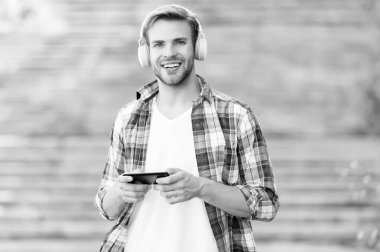 Teknolojiyle kablosuz bağlantıya geç. Mutlu adam akıllı telefondan müzik çalar. Yakışıklı adam kulaklık takıyor. Yeni teknoloji. Mobil teknoloji. Modern hayat. Sadece kulakların için iyi bir teknoloji.