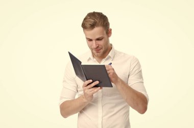 Yazı ustası. Üniversite öğrencisi beyazlar üzerine izole edilmiş yazma ödevi yapıyor. Yakışıklı adam deftere yazı yazıyor. Gazeteci ya da yazar makale için notlar alır. Yazma pratiği. Yazma becerileri. Gazetecilik okulu