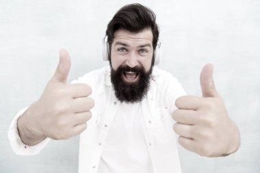 İnsan Duyguları kavramı. Kulaklıklı Müzik Dinleyen Adam. Hippi kulaklıkla harika bir ses şarkısının keyfini çıkarır. Beyaz adam kablosuz bluetooth kulaklık kullanıyor. Mutlu adam başarı için parmağını kaldırdı.