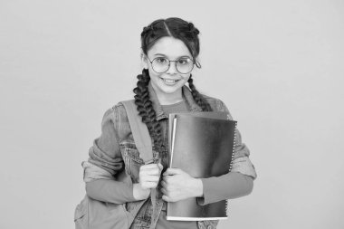 Kütüphane seni hayalperest yapıyor. Kütüphane okuyucusu sarı arka plan. Mutlu kız kütüphane kitaplarını tutuyor. Akıllı kitap kurdu. Okul kütüphanesi. Bilgi ve bilgi. Bibliopol. Kitapçı. İncil Cenneti