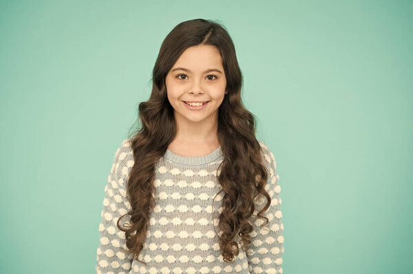 Little girl blue background. Smiling small girl with long hair. Beauty and health. Childhood and girlhood. International childrens day. Child care. Happy childhood. Beautiful kid. Emotional girl