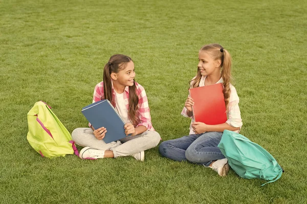 Faire des devoirs ensemble. trouver quelque chose d'intéressant dans le livre. prendre des notes. passer du temps libre après l'école. petits amis enfants se détendre sur l'herbe. retour à l'école. littérature pour filles — Photo