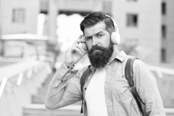 Vive la vida en voz alta con auriculares. Hipster usa auriculares al aire libre. Hombre barbudo escuchar música en los auriculares. Nueva tecnología. La vida moderna. Auriculares para escuchar atentamente — Foto de Stock