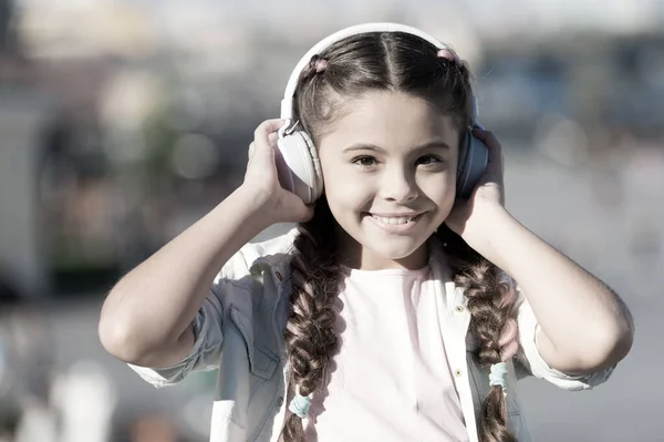 Disfruta de la vida siendo feliz. La música me hace feliz. Feliz niñita. Un niño pequeño escucha música al aire libre. las chicas usan auriculares. Pequeño fan de la música. Estoy muy feliz. — Foto de Stock