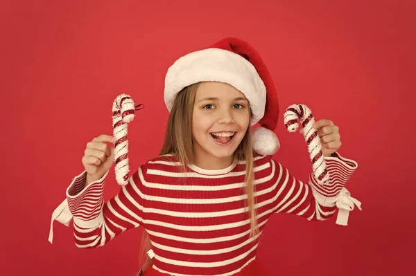 Malá holka se baví. Santa Elf dítě cukrová třtina dekor. vánoční sváteční dekorace. Vánoční nákupy. Šťastnou novoroční oslavu. slavnostní večírek v červené barvě. sladké dětství štěstí — Stock fotografie