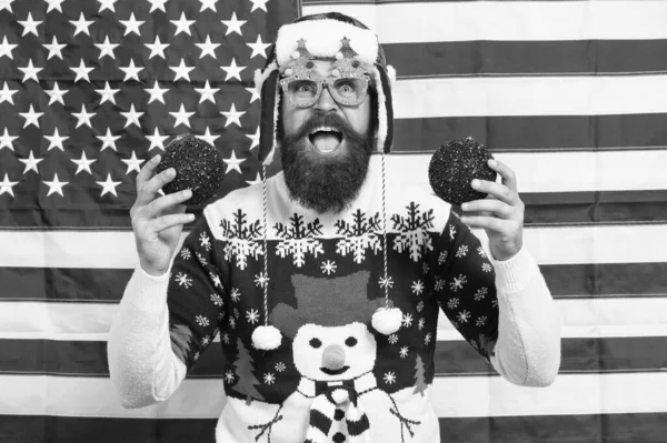 Decore o Natal com patriotismo. Patriótico hipster segurar bolas de árvore de Natal. Um americano barbudo com tomates vermelhos. Bugigangas ou bolas. Decoração de ano novo. Lâmpadas de Natal ou bolas — Fotografia de Stock