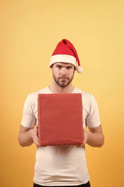 Leveransservice. Kurirockupation. Önskelista. Mannen stilig bära tomte hatt hålla presentförpackning. Hipster håller julklapp. Ge gåva sprida lycka. Gratulationskoncept. Julhälsningar — Stockfoto