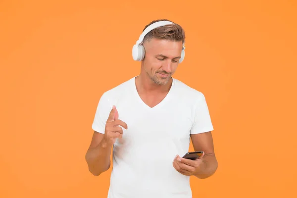 무의미 한 평등 한 자유. 음악 예약. 남자는 현대의 헤드폰과 스마트폰 음악을 듣는다. 경청하는 개념. 최고의 음악 앱. 현대의 사용자 모바일 애플리케이션. 가장 좋아 하는 음악 재생 목록 — 스톡 사진