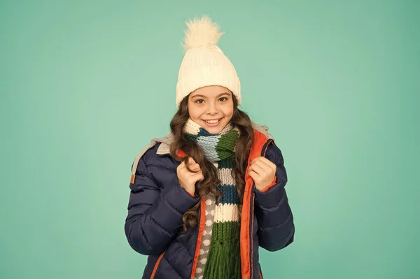 Το παιδί φοράει καπέλο και σακάκι μπλε φόντο. Χειμερινά αθλήματα. Νιώθω άνετα. Ψώνια εποχής. Παιδί με παραγεμισμένο ζεστό παλτό. Εποχιακή μόδα. Χειμερινές διακοπές. Γυναικεία χειμωνιάτικα ρούχα. Τάση μόδας — Φωτογραφία Αρχείου