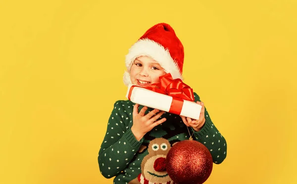 Preparação do ano novo. Natal, hora das compras. loja de brinquedos e presentes para crianças. criança sorridente em Papai Noel. Deixe o seu xmas ser brilhante. felicidade infantil. pequeno elfo segurar presente e bola de decoração — Fotografia de Stock