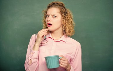 Kadınlar kahveyi sever. Kahve bağımlısı. Vücudunu ve zihnini şarj et. Tüm gün boyunca enerji yüklenmesi. Okul pedagogu için ilham verici bir içki. Bir doz kafein. Öğretmen kahve içiyor, tahtada yazı tahtası var.