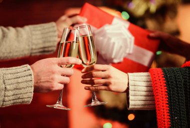 Bir bardak şampanya. Noel tatili için hediye. Sevgiyle hediye. Erkek kadına kutu verir. Aile değerleri. Birbirine aşık çiftlerin elleri. Mutlu noeller. Mutlu yıllar. Hafta sonu kış tatili. seçici odak