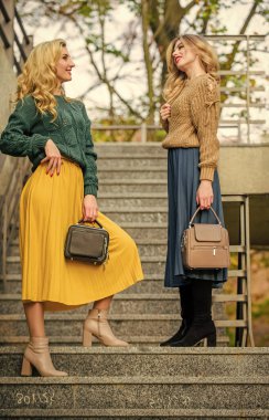 Herhangi bir havada iyi bir ruh hali. Kız arkadaşlar yukarı çıkar. Sonbahar renk trendleri. Pileli trend. Etek ve süveter giyen kızlar. Kadın güzeli. Örgü giyme modası. Havalı sonbahar kadınları açık havada