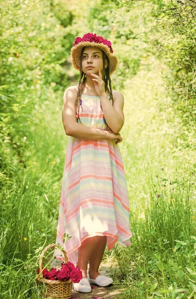 Eco living. child walk in spring park or garden. small girl with summer rose bouquet. summer holiday and vacation. female beauty and fashion. childhood happiness. happy kid gather flowers