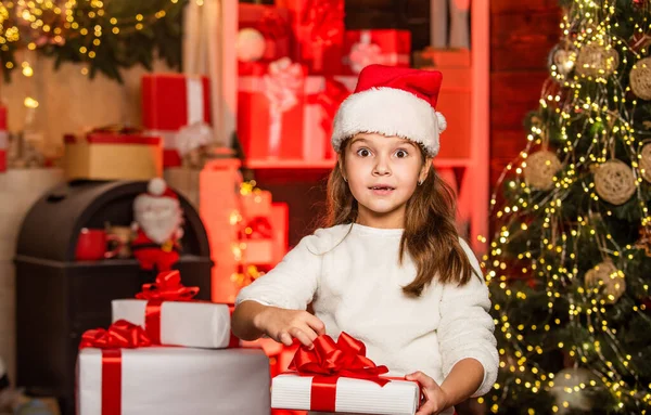 寒假小女孩拿着礼品盒。小孩拿着礼品盒装饰内部的背景.神奇的时刻圣诞节礼物的采购。家庭传统。礼品包装。圣诞快乐，节日快乐 — 图库照片