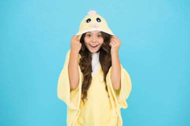 Mutlu bir çocukluk. Uzun saçlı çocuk pelüş pijama giyiyor. Çok güzel pijamalar. Kapüşonlu şirin pijama giyen küçük bir kız. Rahat ve rahat hissediyorum. Çocuk modası. Ev kıyafetleri.