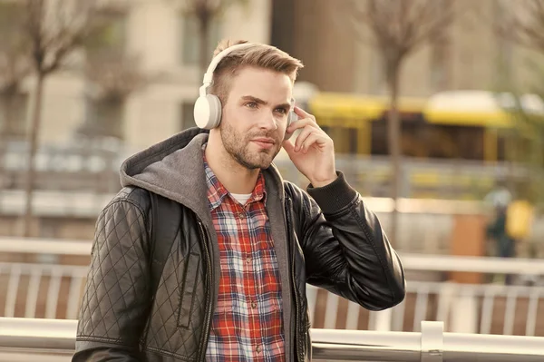 Müzik, ses ve teknoloji. Yakışıklı adam dışarıda kulaklık takıyor. Traşsız adam sokakta müzik dinler. Yeni teknoloji. HiFi teknolojisi. Modern müzik teknolojisi. Modern hayat