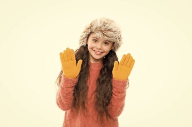 Oyuncu modacı. Uzun saçlı çocuk yumuşak kürk şapkası yumuşaklığın tadını çıkarır. Yumuşak bakım konsepti. Sahte kürk trendi. Uzun saçlı bir kız beyaz kürk şapka takıyor. Yünlü giysiler için yumuşatıcı. Yumuşak duygular