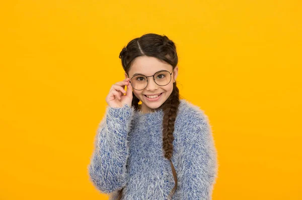 Ευτυχισμένη έφηβος κορίτσι με πλεγμένα μαλλιά φορούν γυαλιά για διόρθωση της όρασης σε κίτρινο φόντο, την υγεία — Φωτογραφία Αρχείου