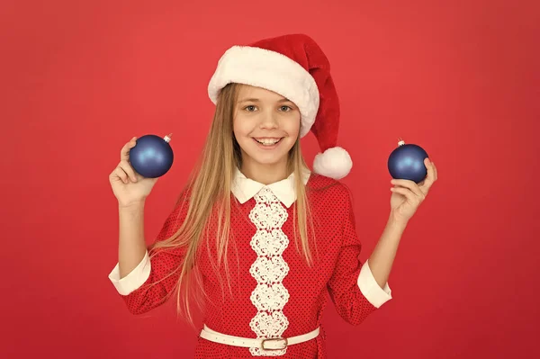Weihnachtskugeldekor vorhanden. Weihnachtliche Deko-Ideen für das Kinderzimmer. Kind rote Kostüm halten Weihnachtsschmuck. Je früher man Dekorationen kauft, desto billiger werden sie. Einzigartige Dekorationen schaffen — Stockfoto