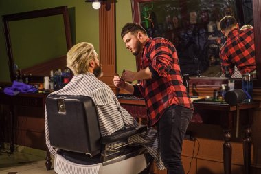 Berber dükkanında müşteriye hizmet eden kuaför. Kişisel kuaför. Eski ve eski moda. Saç kesimi tasarlıyorum. Berber dükkanında berber aletleri. Yakışıklı kuaför erkek müşterinin saçını kesiyor.