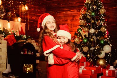 Noel ziyafeti. Yılbaşı zamanı. Kış tatillerini severim. Noel hediyesini bekle. Kırmızı Noel Baba şapkalı küçük kızlar. Kış alışverişi. Küçük kız kardeşler hediye ister. Mutlu aile yeni yılı kutluyor.