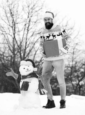 Eğlence ve eğlence. Adam gülen surat, karlı doğa geçmişi. Kış oyunları. Kış aktivitesi. Kış tatili Adam kardan adam yaptı. Açık havada sakallı hippi. Noel Baba şapkalı adam dışarıda eğleniyor.