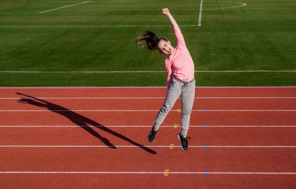 Feliz ganador. corredor en la competencia celebrar el éxito. Sprinter ganó en el gimnasio del estadio. Ganador. niño en la escuela lección de educación física. pura felicidad. Ella es muy feliz. adolescente chica es un campeón — Foto de Stock