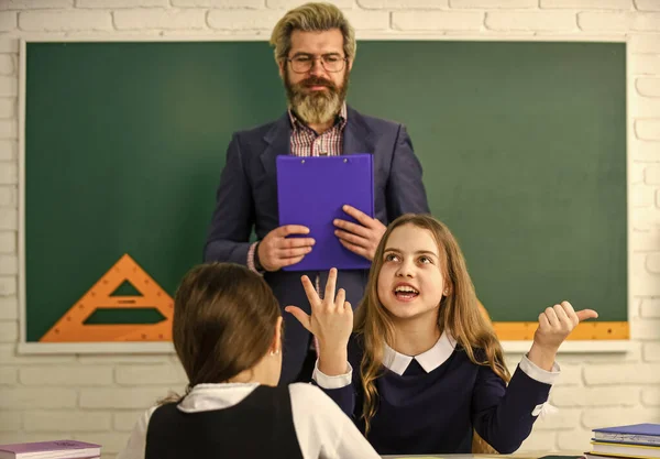 Conversatie. Docent werkt met creatieve kinderen. kleine meisjes kinderen op school. terug naar school. Leraar en leerlingen werken samen aan een bureau op de basisschool. creativiteit openbaar te maken en te ontwikkelen — Stockfoto