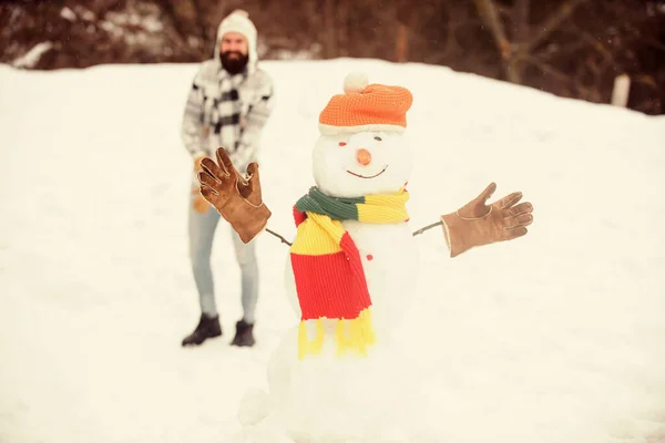 Családi nyaralás. téli szezon tevékenység. Karácsony van. Boldog hipszter készen áll, hogy megünnepeljük a karácsonyt. Az ember játszik a hóval. téli vakáció szabadtéren. meleg pulóver hideg időben. szakállas ember építeni hóember — Stock Fotó