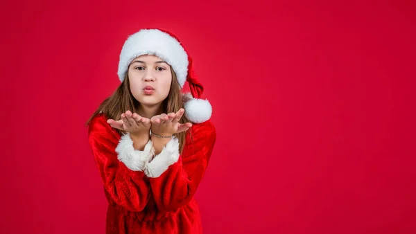 Glad jul flicka unge bär röd tomte klo hatt och kostym skicka kyssar, hälsning — Stockfoto