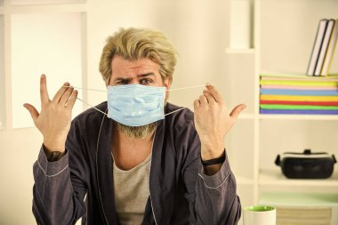 Adam yüz maskesi tutuyor. Virüs damlacıklarla ve yakın temasla bulaşır. Maske takıyor Virüslerden koruyor. Eğer maske takıyorsan, nasıl kullanılacağını ve nasıl kullanılacağını bilmelisin. Koronavirüsten koru.