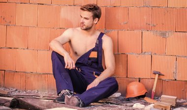 Bina inşaatı. İnsan kendi evini inşa eder. Çekici bir işçi. Yakışıklı, seksi işçi. İnceleme binası. Genel bakım işçisi tamirhaneyi onarmaya devam edin. İşçi tuğlası duvar arkaplanı