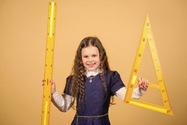 Öğrenci geometri okuyor. Çocuk okulu üniforması cetveli tutar. Matematiği severim. Eğitim ve okul konsepti. Zekice ve zekice bir fikir. Boyut ve boyut. Büyük cetvelli tatlı kız.