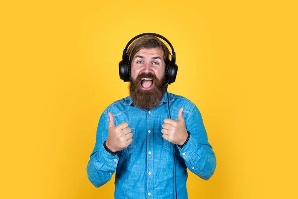 Kaukasiska hipster med skägg och elegant hår i headset med tumme upp, framgång — Stockfoto