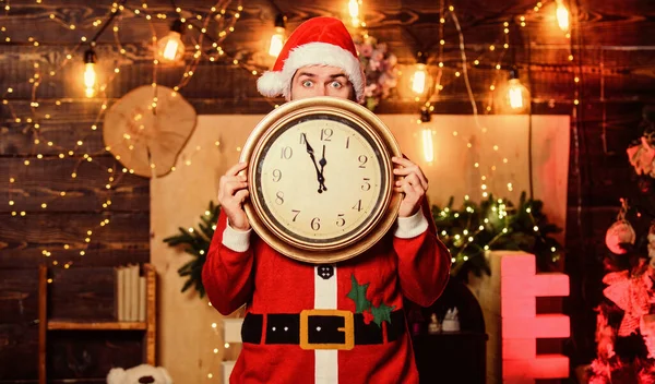 Zeit zum Feiern. Frohe Weihnachten. Bärtiger Mann, der die Zeit informiert. Zeit für ein Winterfest. Machen Sie sich bereit. Nur noch wenige Minuten. Countdown zum neuen Jahr. Fast Mitternacht. Wünsch dir was. Weihnachtsmann hält Oldtimer-Uhr — Stockfoto