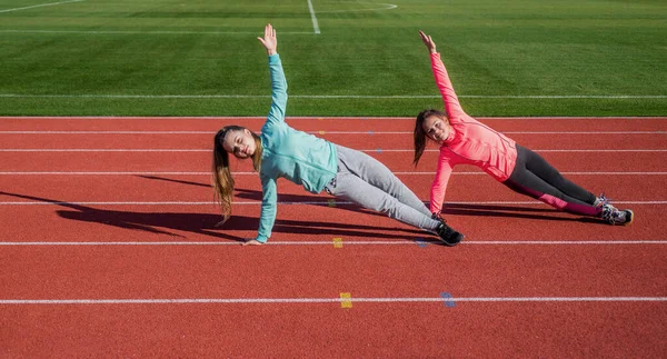 Meninas adolescentes de pé na prancha lateral no estádio ao ar livre, aquecimento — Fotografia de Stock