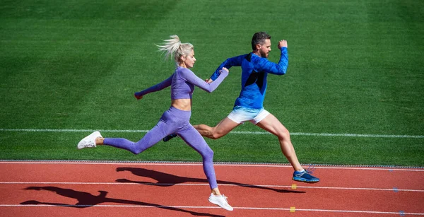 Ακραία προπόνηση. αθλητικό ζευγάρι τρέχει γρήγορα για να κερδίσει. επιτυχημένες σπρίντερς γυμναστικής. Ο αθλητικός άντρας και η σέξι γυναίκα διαγωνίζονται στο σπριντ. Αρσενικό και θηλυκό σε πίστα στίβου. υγιεινό τρόπο ζωής. ταχύτητα μαραθωνίου — Φωτογραφία Αρχείου