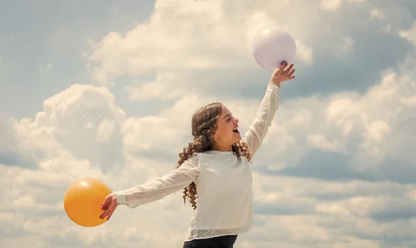Party time. express positive emotions. just have fun. freedom. summer holidays celebration. international childrens day. Happy child with colorful air balloons over blue sky background
