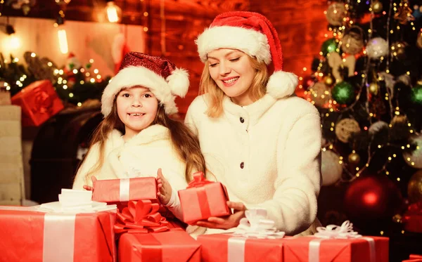 寒假送给女孩的礼物妈妈和孩子带着礼品盒给女儿的惊喜节日快乐新年传统。节礼日在圣诞树旁包装好的礼物。为家人准备礼物 — 图库照片