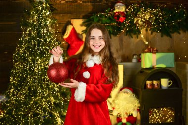 Dekorasyon kiralama servisi. Mutlu bir çocukluk. Küçük kız Noel 'i kutluyor. Tatil aksesuarları kiralık. Kış tatili konsepti. Noel ağacının yanında yeni yılı kutlayın. Arnival kostüm kiralama