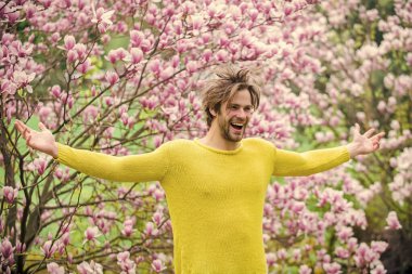 Bahar sezonu. İlkbahar konsepti. Tıraşsız bir adam manolya çiçeği koklar. Erkek çiçekli arka plan çözüldü. Bahar güzeli. Botanik ve doğa. Mutlu bahar konsepti. Hippi çiçekli aromanın tadını çıkarır.