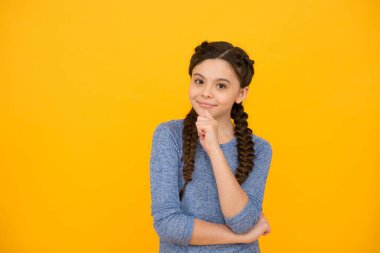 Gülümseyen, sarı arka planda örülü saçları olan güzel bir kız.