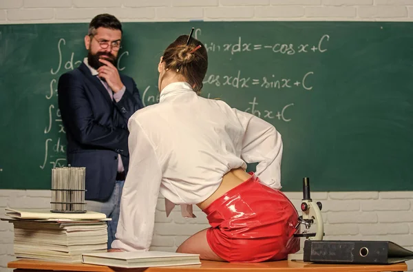 Iedereen droomt over zo 'n leraar. Lustvolle leraar. Experimenteren met gevoelens. Aantrekkelijke leraar latex rok. Brutale leraar. Onbeschaamde student. Flirtende collega. Meisje sexy billen zitten tafel — Stockfoto